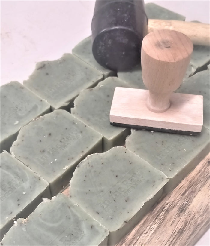 Green handmade soap bars with a wooden soap stamp