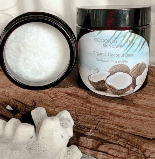 three amber jars of organic coconut balm with tropical labels, showcasing smooth, white balm inside one open jar, placed on a natural fabric background.