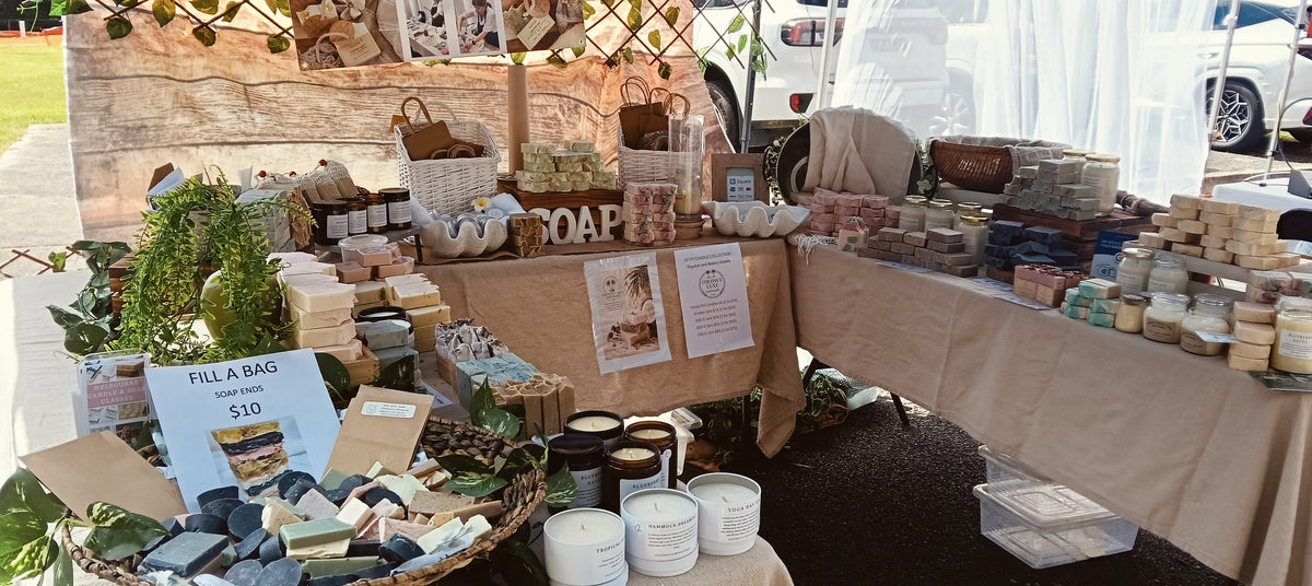 Coconut Luxe Naturals market stall with handmade soaps and coconut wax candles